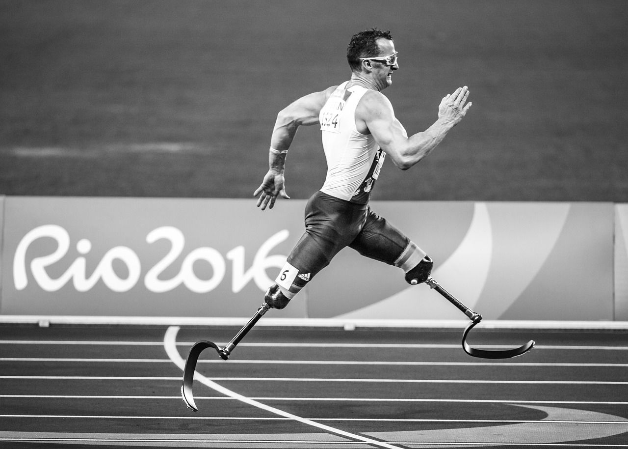 Black and white image of a man with two prosthetic legs running in a race