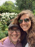 Andrew with his wife.  They are outside and smiling.