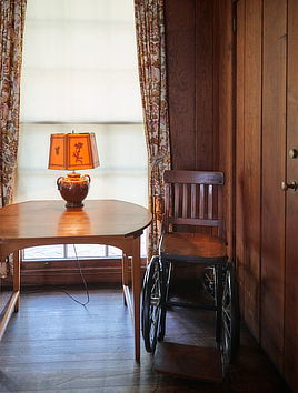 FDR's wheelchair next to a table with a lamp