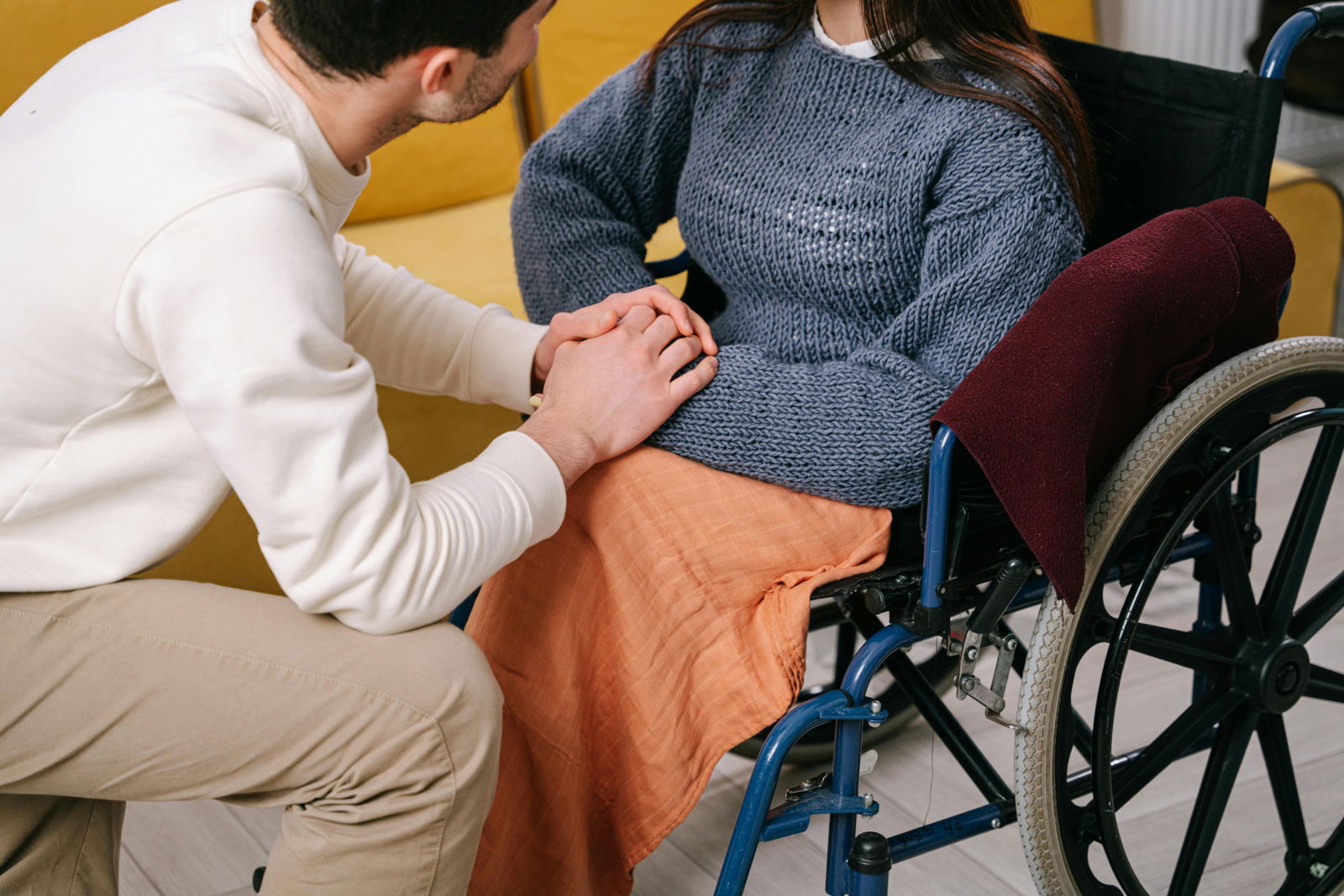 Man holding hands with a woman in a wheelchair